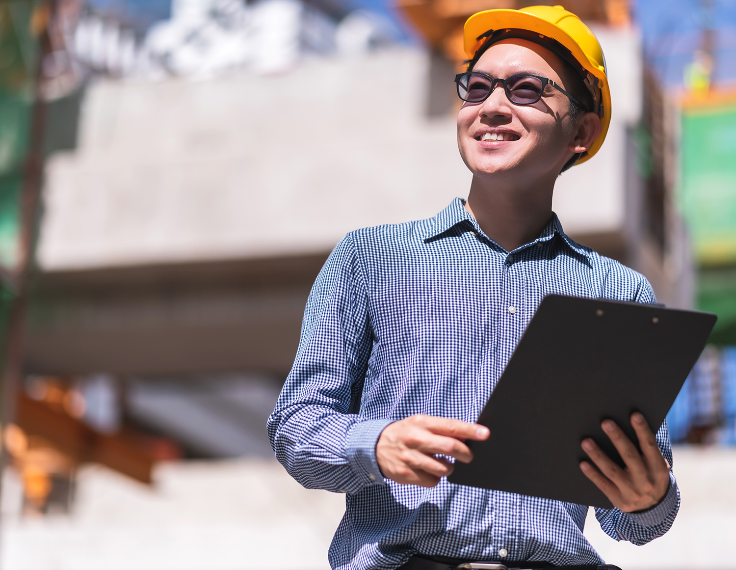 Smart asian engineer manager with safety uniform checking site construction with steel concrete structure background
